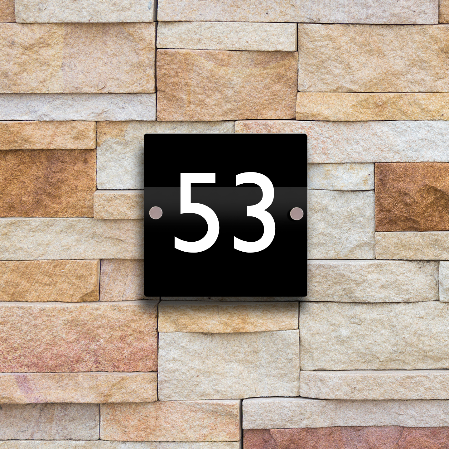 A contemporary and professional looking glossy black sign with white raised numbers. It is affixed to an exterior wall with stainless steel stand-off fittings.