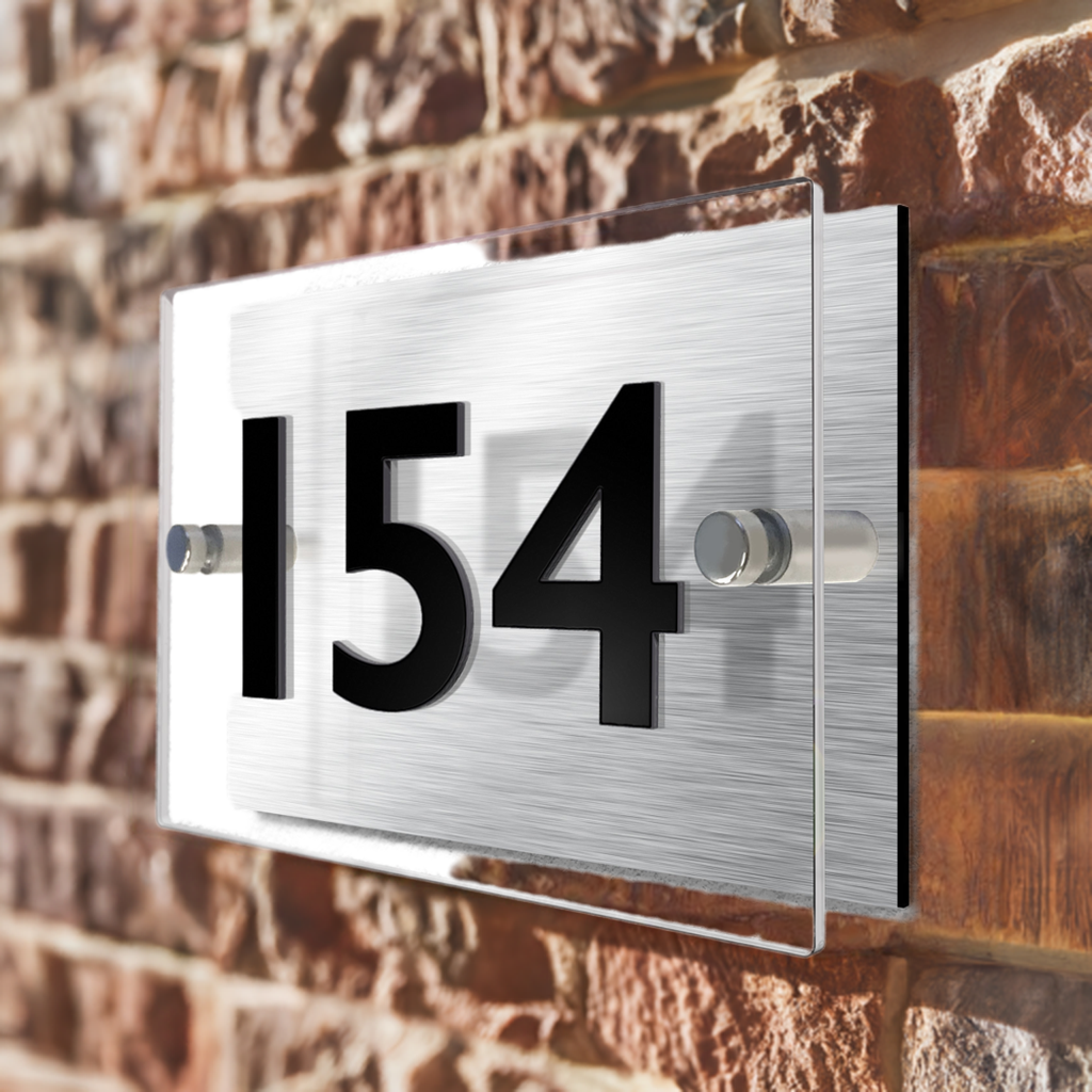 Alumina house sign on a brick wall. The sign is angled and the photo has perspective.