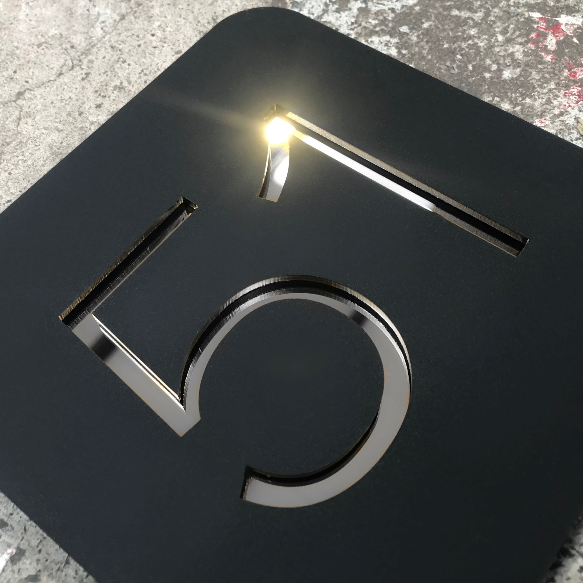 A Stellito Acrylic House Number Sign with highly reflective silver mirror numbers.